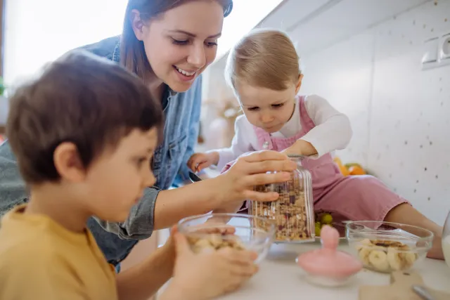 Niños y su mamá comiendo nueces pecanas y frutos secos