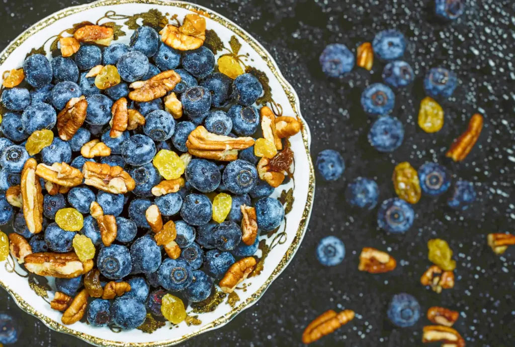 Un tazón con nueces, frutos secos y moras azules.