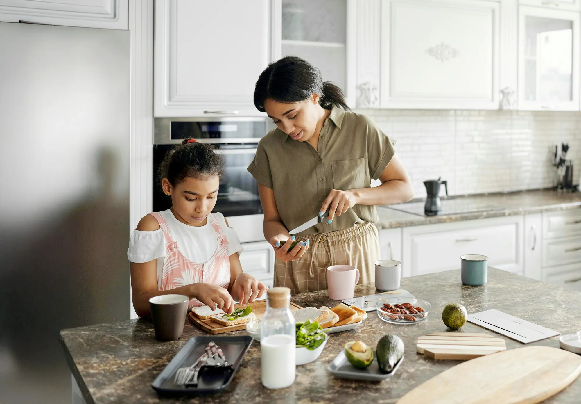 Mamá preparando el lunch junto a su hija en la cocina